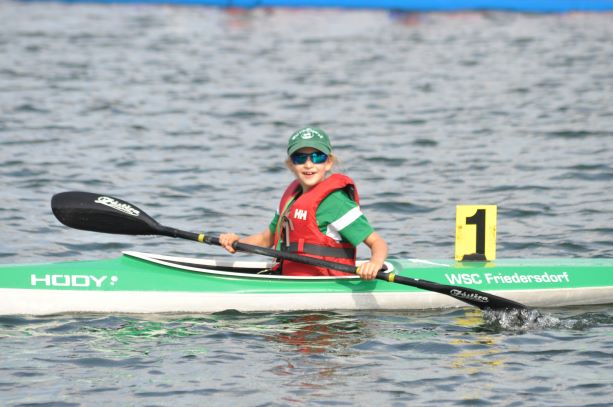 Ein Bild von einem Kind, was in einem Kajak sitzt.